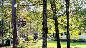 A street sign with 'Town House 9' and a house number '179' in a lush, green area with trees and a sidewalk.