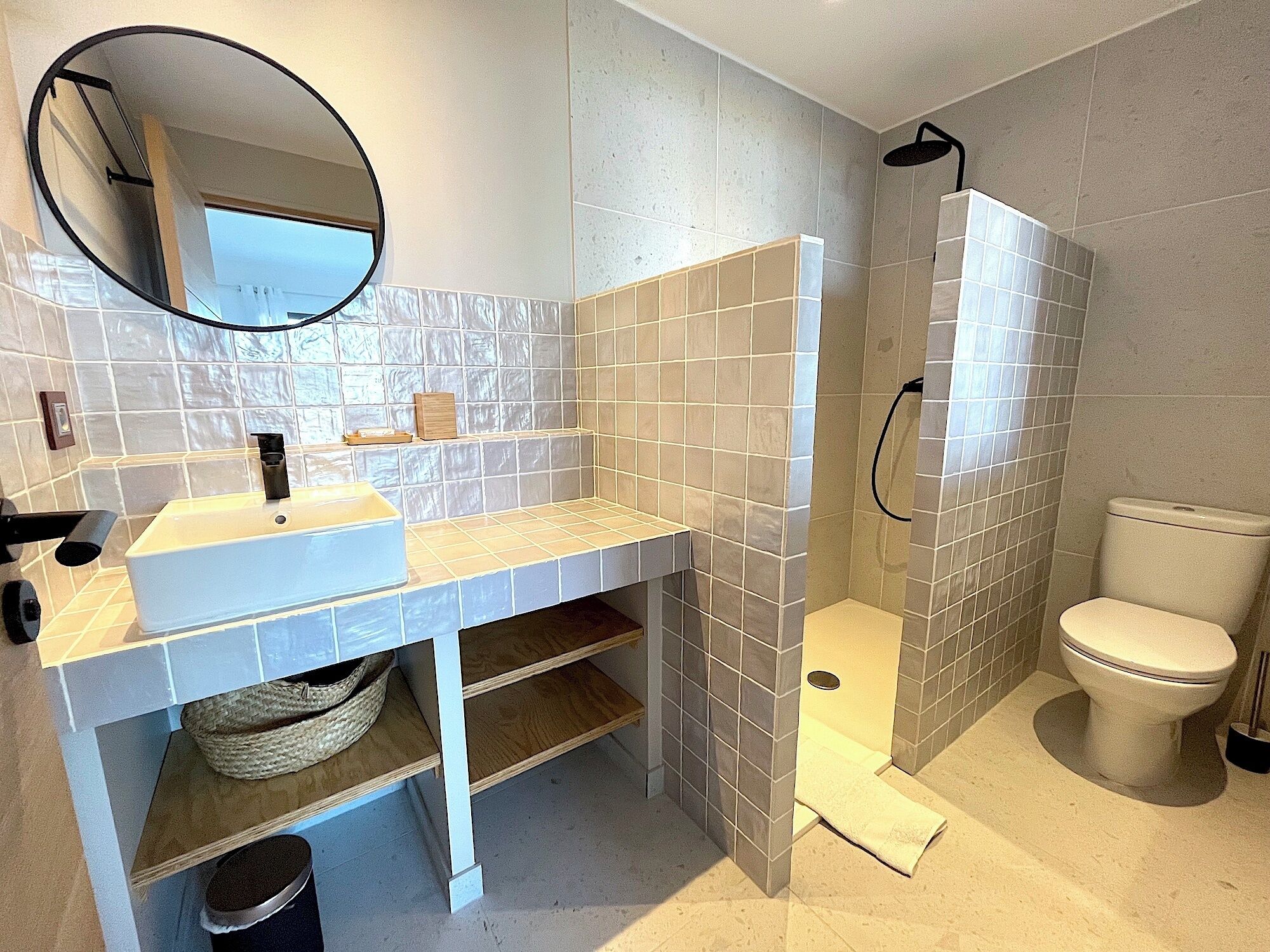 Ein modernes Badezimmer mit Waschbecken, Spiegel und Toilette.