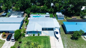 Un quartier résidentiel comprenant plusieurs maisons, une piscine et un bateau amarré à l’extérieur.