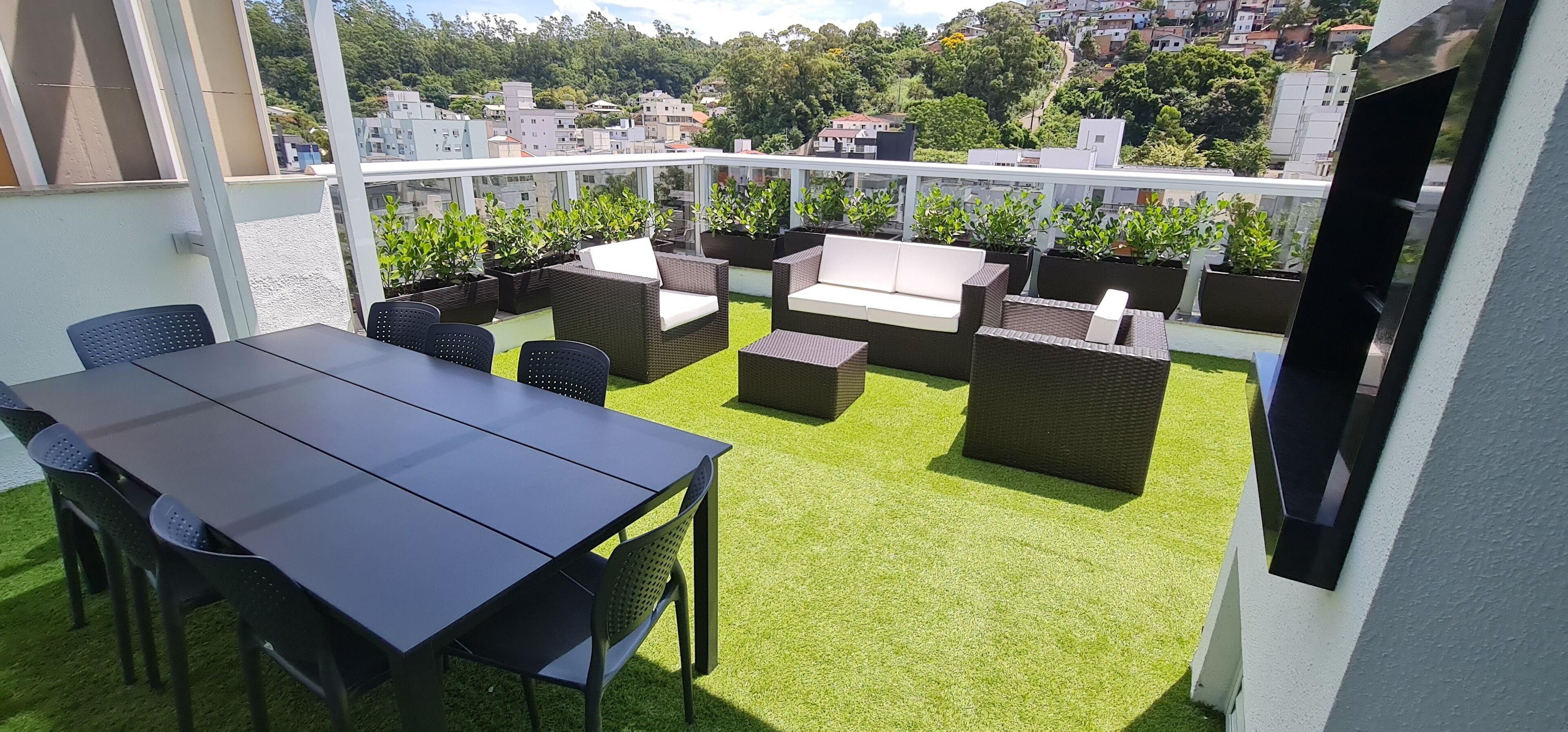 Une terrasse sur le toit équipée d’une table à manger, de chaises et de canapés.