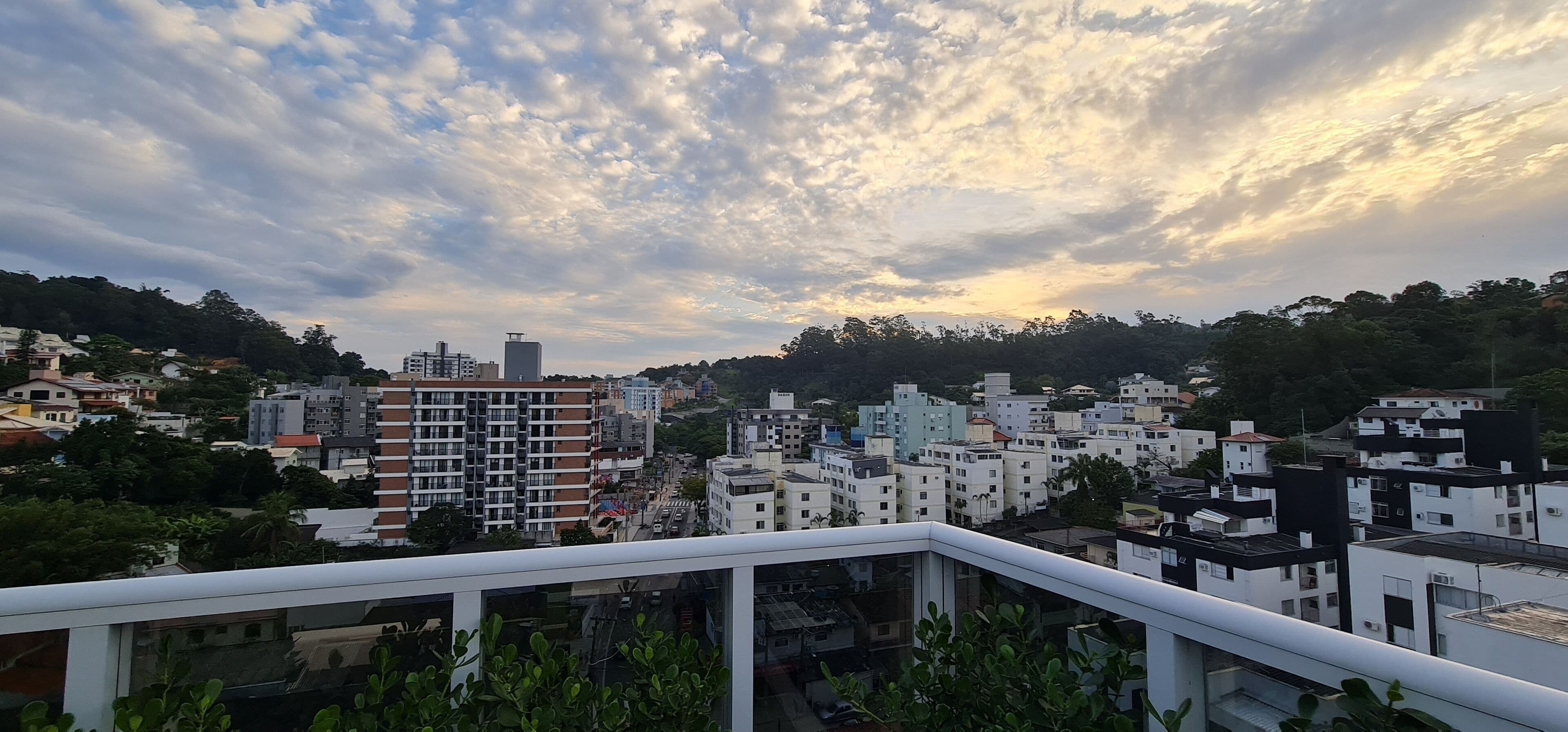 Paisagem urbana com diversos edifícios, incluindo residenciais e comerciais, sob um céu nublado.