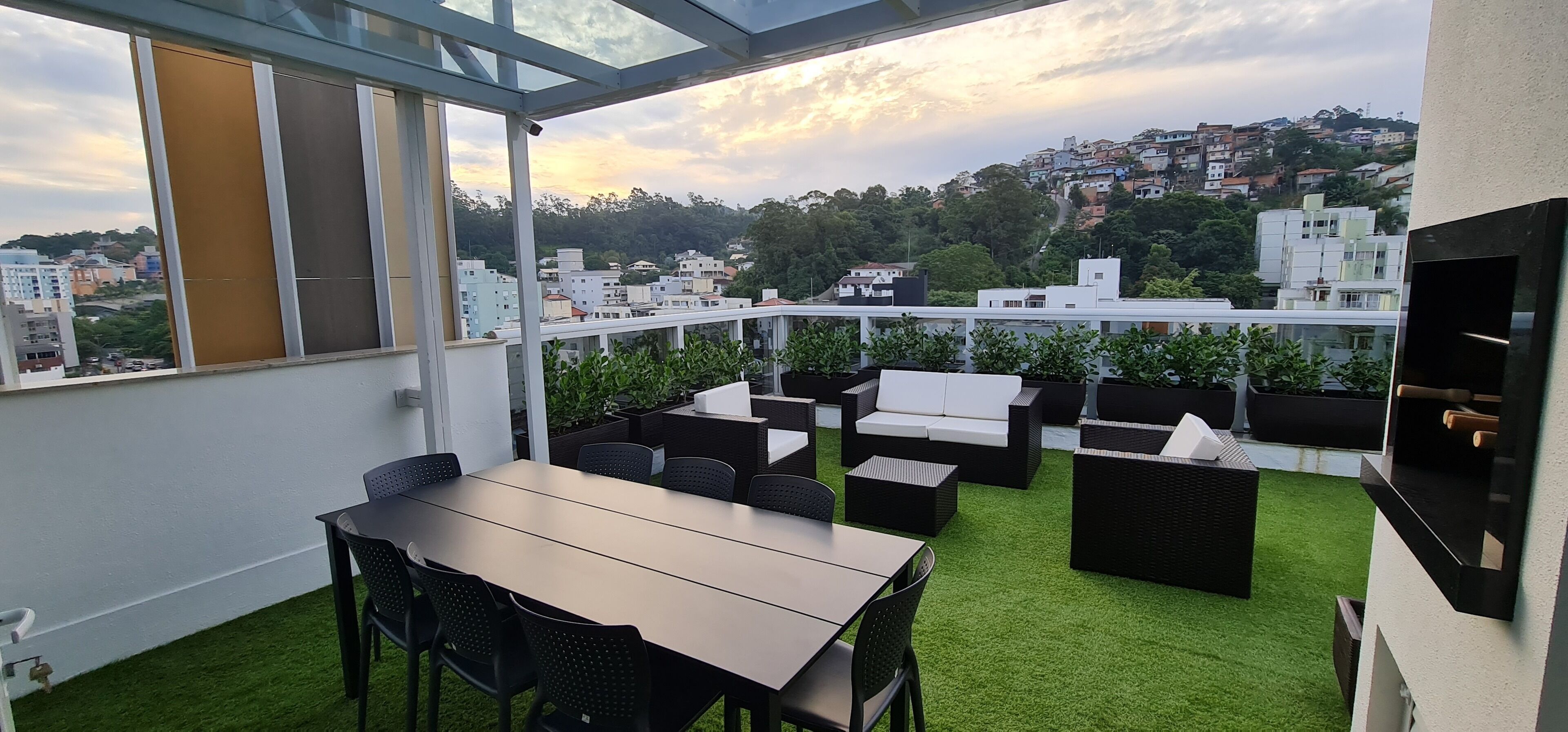 Eine Dachterrasse mit Essbereich, Gartenmöbeln und Blick auf die Stadtlandschaft.