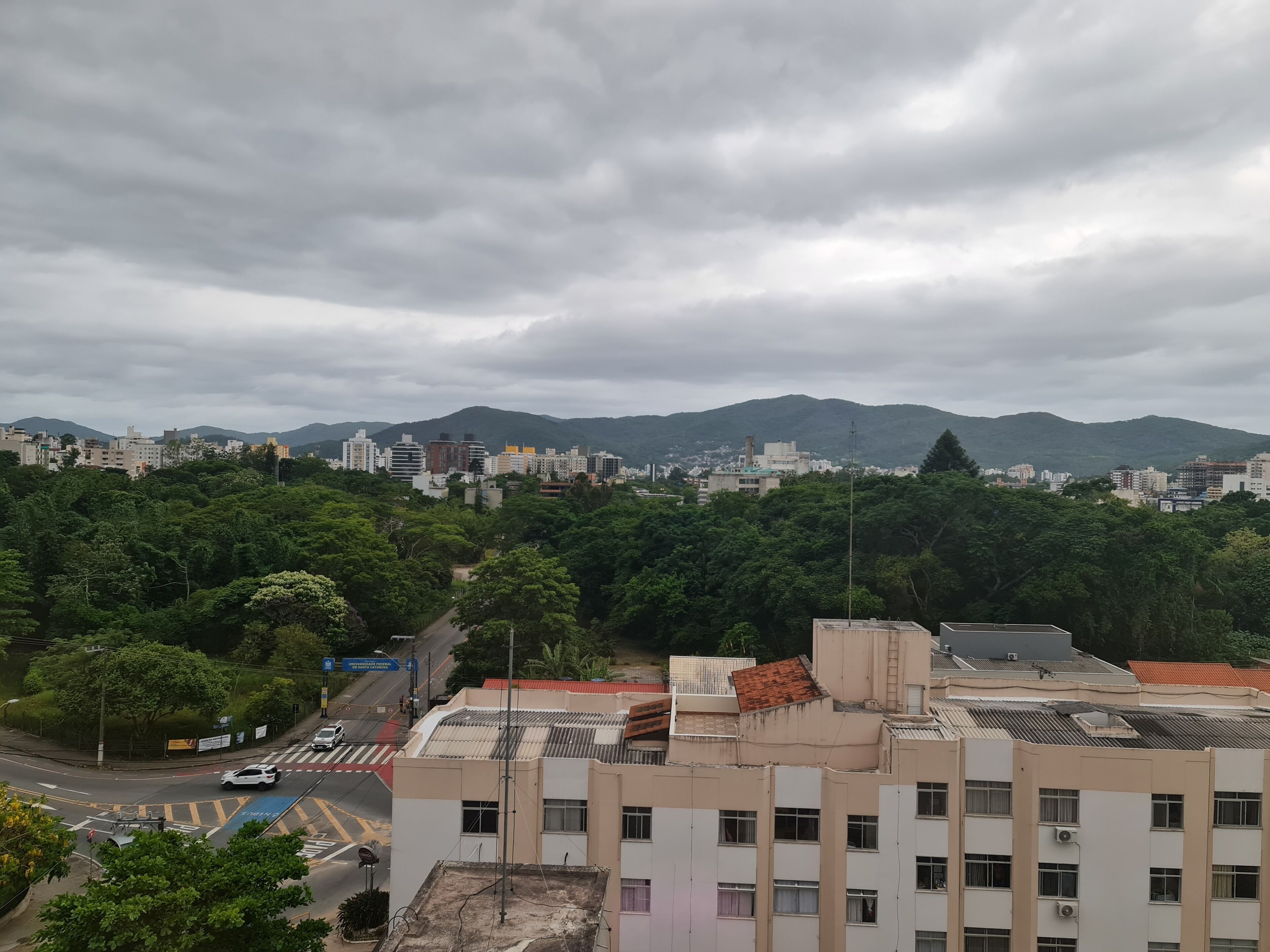 A cityscape with buildings, a road, and a mountain range in the background.