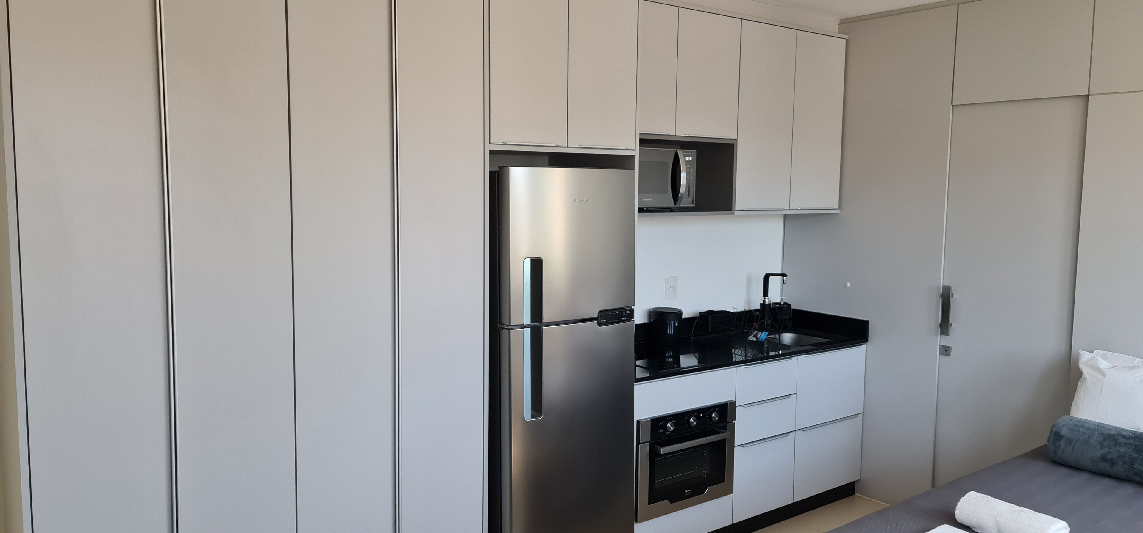 A modern kitchen with a built-in refrigerator, oven, and microwave.