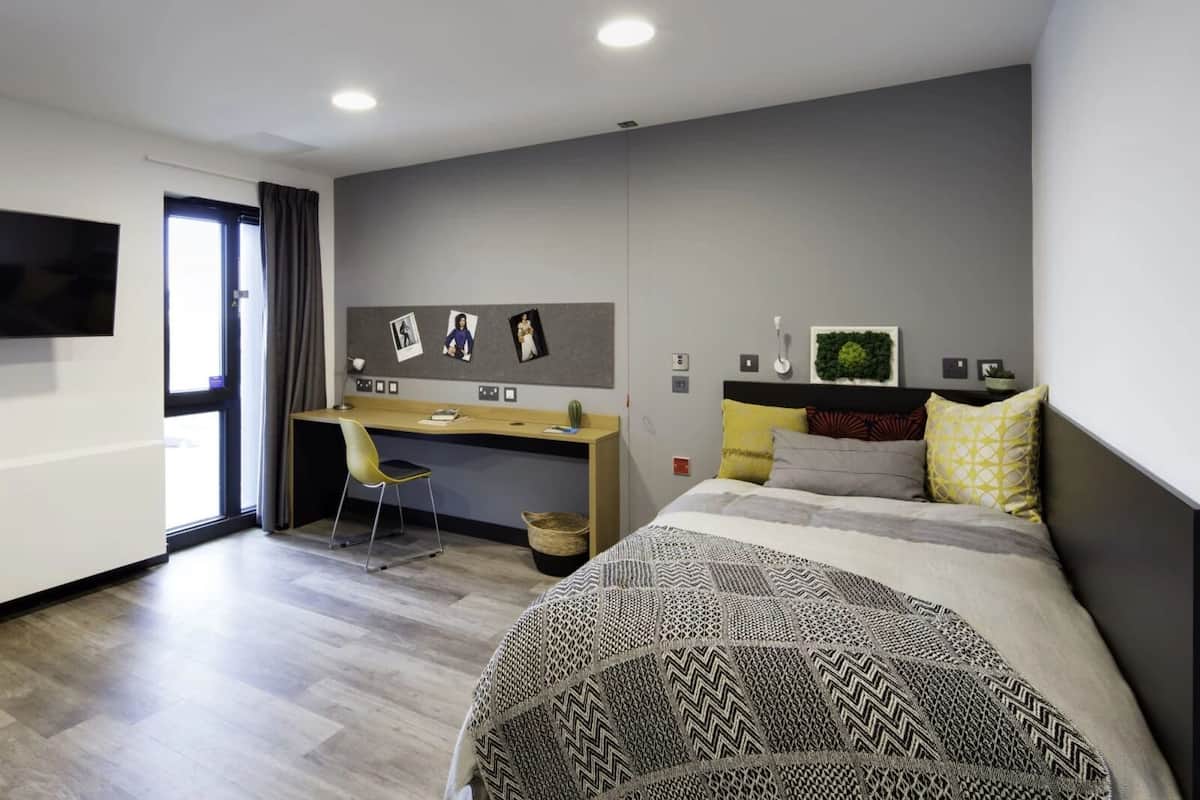 A modern bedroom with a bed, a desk, and a chair.