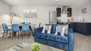 A modern kitchen with dark cabinets, a white countertop, and a built-in stove. - Buzzing Brighton Apartment 1 | By My Getaways (Brighton)