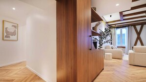 Een moderne woonkamer met een houten accentmuur, een bank, een salontafel en een potplant.