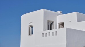 Un bâtiment blanc doté d’un toit plat et d’une petite fenêtre.