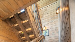 Un escalier en bois avec une rampe en métal et un tableau accroché au mur.