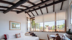 A bedroom with a bed, a sofa, a dining table with chairs, and a large window with a view of the outside. - NEW Flat - Valeria Terrace - Monti, Rome (Roma)