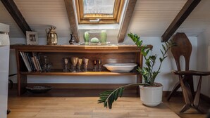 A cozy attic space with a sloped ceiling, a skylight, a wooden shelf with decorative items, and a potted plant. - NEW Flat - Valeria Terrace - Monti, Rome (Roma)