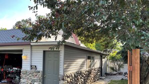 Una casa amb garatge, mur de pedra i tanca de fusta.