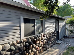 Una casa con cimientos de piedra y techo de metal.