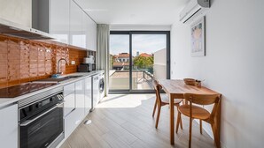 Eine moderne Küche mit Backofen, Spüle und Essbereich mit Tisch und Stühlen.