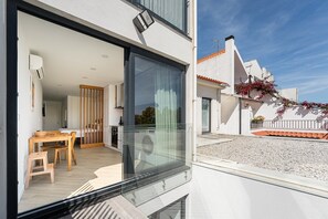 Un appartement moderne doté d’un balcon, d’un coin repas et d’une cuisine.