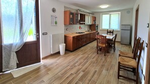 Une cuisine spacieuse avec des meubles en bois, une table à manger et des chaises.