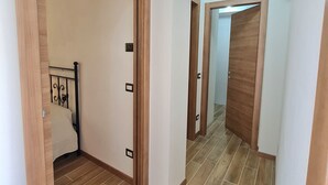 Un couloir doté d’un plancher en bois et de portes donnant sur les chambres.