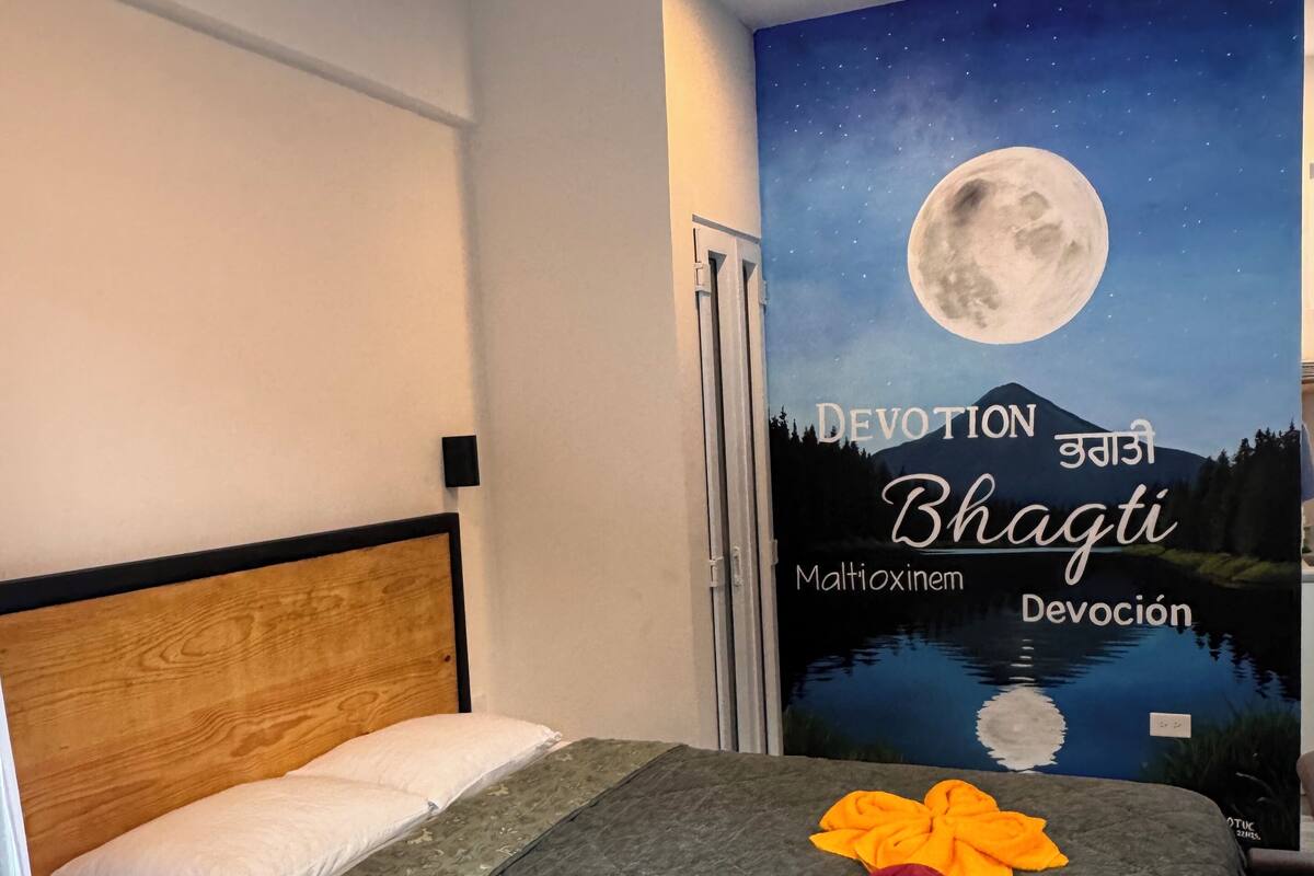 Una habitación de hotel con una cama, un mural del cielo nocturno y una puerta.