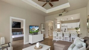 A modern living room with a flat-screen TV, a white entertainment unit, and a sofa. - Exceptional 3 bed and 3 bath Reunion Resort condo, with stunning golf views!  (Kissimmee)