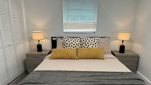 Una camera da letto ordinata con un letto, due comodini e una finestra con persiane.