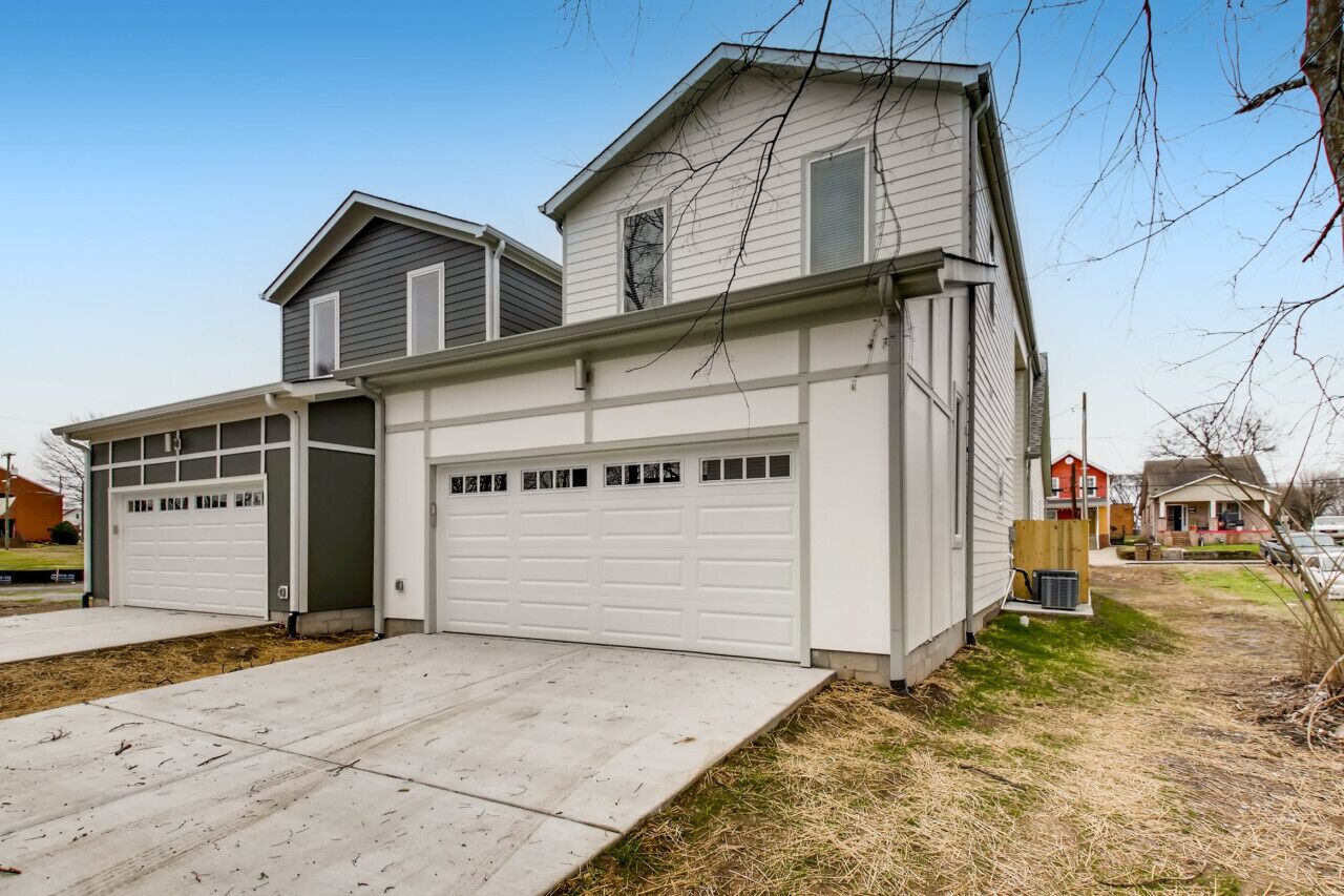 A two-story house with a garage and a covered driveway.