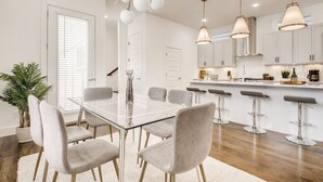 A modern kitchen with white cabinets, a central island, and bar stools.