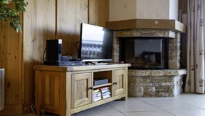 Een houten tv-meubel met een flatscreen televisie en een open haard.