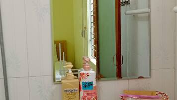A bathroom with a white sink, a glass shower enclosure, and a mirror above the sink.