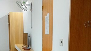 Una habitación con un banco de madera, un escritorio y una puerta.