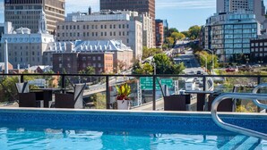 A rooftop pool with a city view, including buildings and a highway. - Rustique, NEW in Quebec city - 2 rooms + 2 bathroom (pool on roof during summer) (Québec)