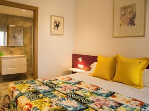 Relax in a stylishly designed room with a comfortable bed, bedside table, and large mirror.
