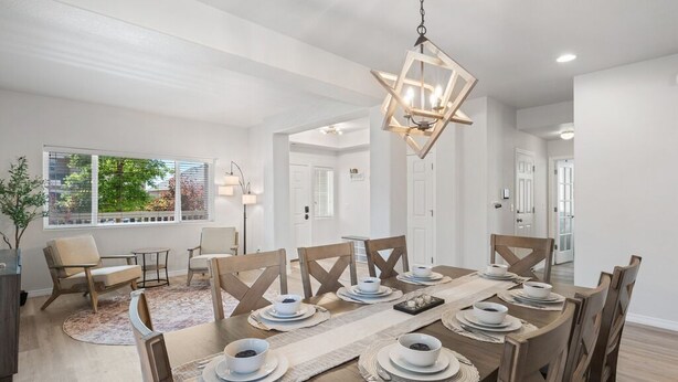 Un coin repas avec une table en bois dressée pour six personnes, entourée de six chaises.