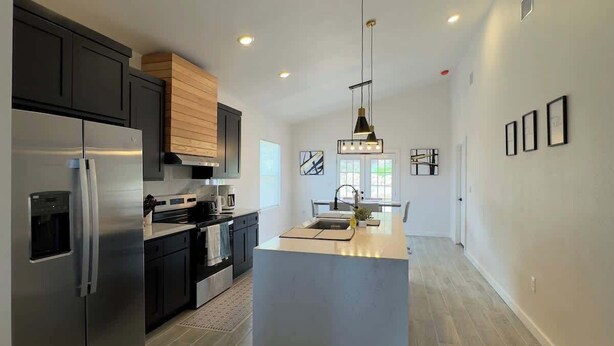 A modern kitchen with a central island, stainless steel appliances, and recessed lighting. - Family-Friendly Retreat in Canyon Lake (Canyon Lake)