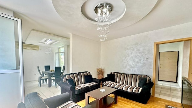Una sala de estar moderna con un conjunto de sofá, una mesa de centro y un televisor.