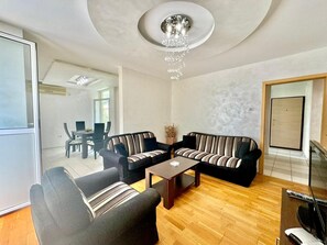 A modern living room with a sofa set, a coffee table, and a television. - Family three bedroom Apartment Petrovac (Petrovac)