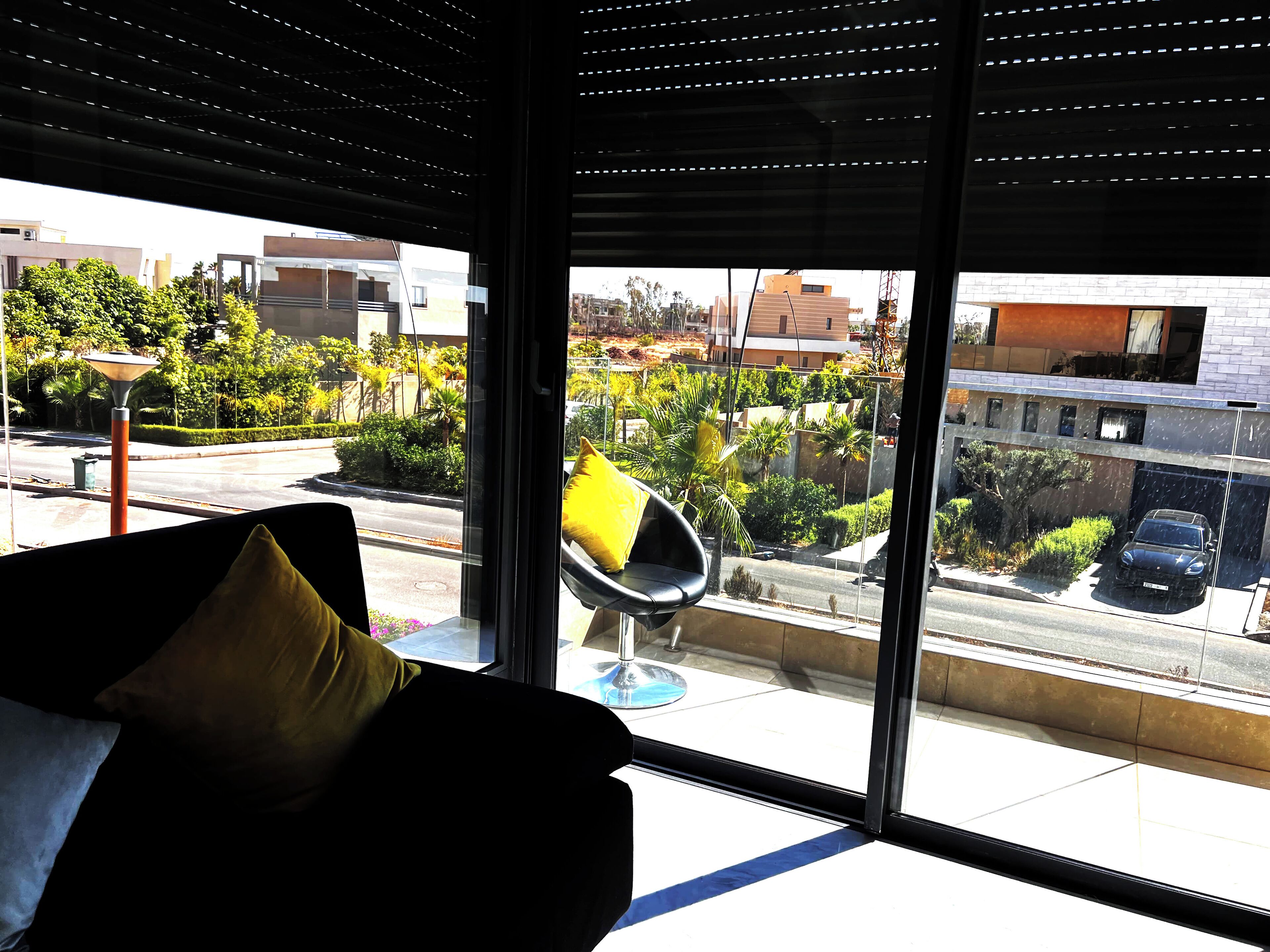 Ein modernes Zimmer mit großem Fenster, einem Sessel und einer Couch.