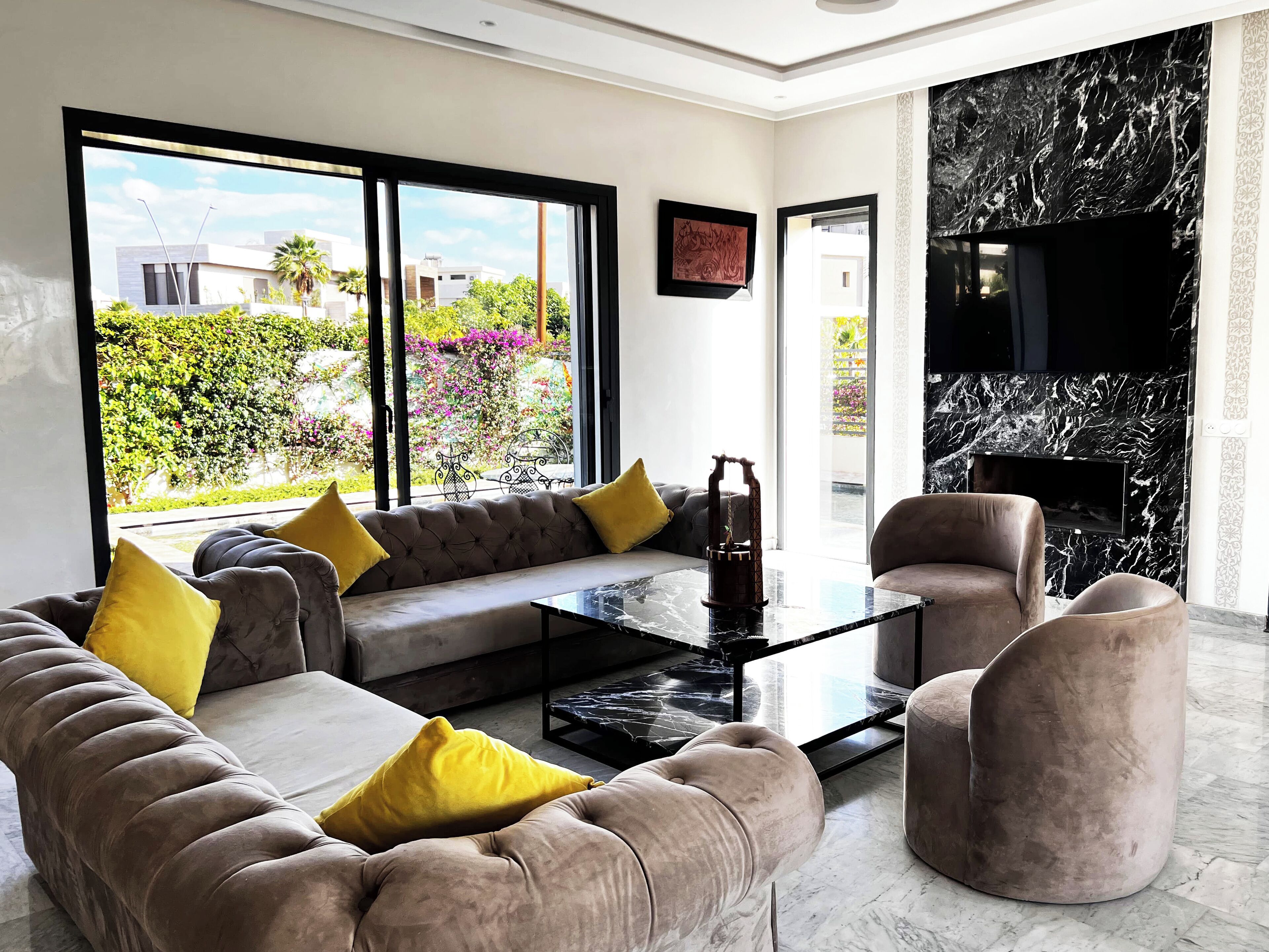 A modern living room with a sofa, armchairs, and a coffee table.