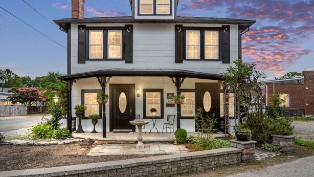 A two-story house with a porch, a small garden, and a birdbath. - Historic charm with modern amenities (Colonial Beach)