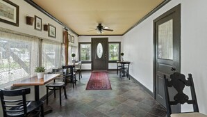 A hallway with a dining area, a ceiling fan, and a door with a window. - Historic charm with modern amenities (Colonial Beach)