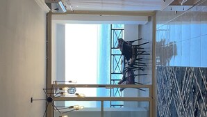 A room with a large window, a dining table with chairs, a chandelier, and a view of the sea. - sea view apartment 06 (Red Sea Governorate)