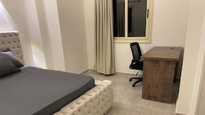 A bedroom with a bed, a desk, and a chair. - sea view apartment 06 (Red Sea Governorate)