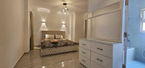 Un dormitorio con cama, mesitas de noche, armario y baño.