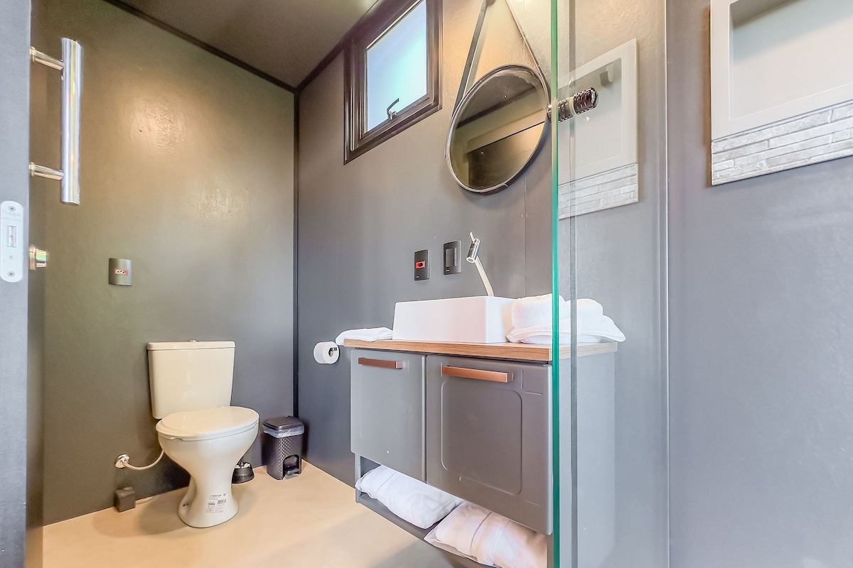 A modern bathroom with a toilet, sink, and mirror.