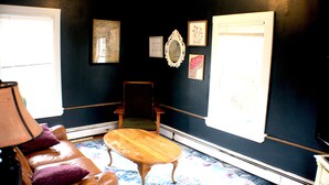 A room with a leather sofa, a wooden coffee table, a chair, and a large mirror on the wall. - Cozy Pet Friendly House Next To Train (Canton)
