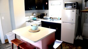 A compact kitchen with a stove, microwave, and sink. - Cozy Pet Friendly House Next To Train (Canton)