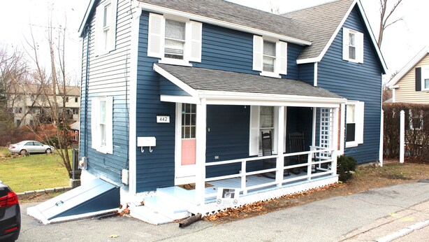 A two-story house with a porch, a ramp for accessibility, and a mailbox. - Cozy Pet Friendly House Next To Train (Canton)