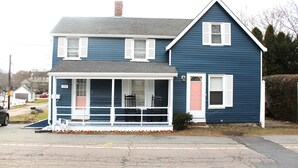 A two-story house with a front porch, a garage, and a pink door. - Cozy Pet Friendly House Next To Train (Canton)