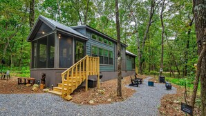 A cabin with a wooden staircase, a deck, and a view of the forest. - Tiny Bear Paw-relax, unwind and recharge (Mentone)