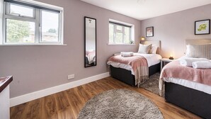 A bedroom with two beds, a large mirror, and a window. - Link Road House By REDWOOD STAYS (Alton)