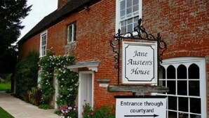 A brick building with a sign reading "Jane Austen's House" and a directional sign indicating "Entrance through courtyard." - Link Road House By REDWOOD STAYS (Alton)